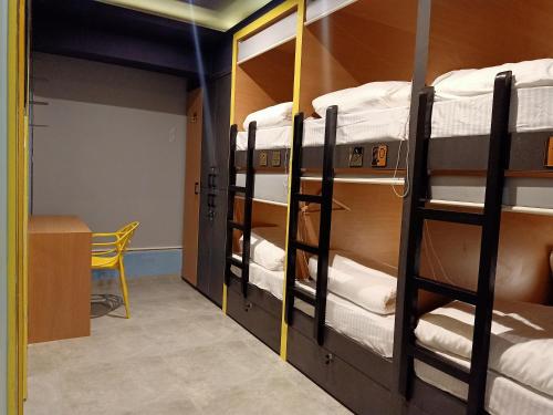 a room with three bunk beds and a desk at Stayvilla Hostel in Mumbai