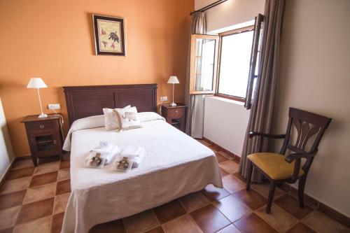 a bedroom with a bed and a chair and a window at La Casa de Las Titas in Vélez-Málaga