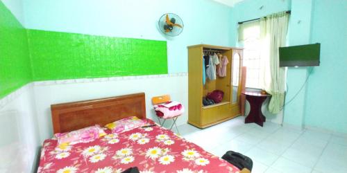 a bedroom with a bed and a green wall at Hostel Loc Quyen in Da Nang