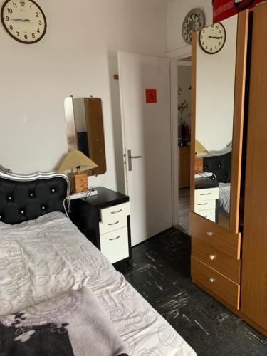 Schlafzimmer mit einem Bett, einer Kommode und einem Spiegel in der Unterkunft Une chambre single avec accès direct Aéroport d'Orly T4 in Orly