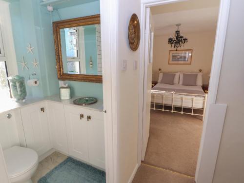 een badkamer met een toilet en een bed in een kamer bij Woodbine Cottage in Maryport