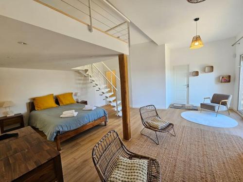 1 dormitorio con cama, sillas y escalera en Belle villa avec vue mer- A deux pas de la plage, en Brando