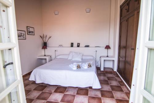a bedroom with a white bed and a tiled floor at La Casa de Las Titas in Vélez-Málaga