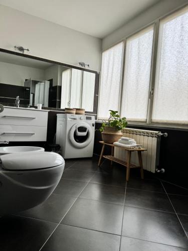 a bathroom with a toilet and a washing machine at Le Tre Ca', Ca' Cecilia, Ca' Nina, Ca' Vittoria in Asti