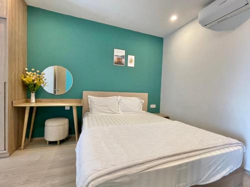 a bedroom with a bed and a desk with a mirror at The Song Luxury Vung Tau Apartment - QUỲNH's Homestay in Vung Tau