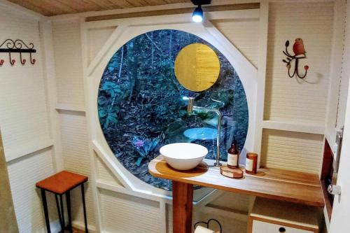 a small bathroom with a sink and a window at Tiny House da serra perto de São Paulo em meio a natureza in Mairiporã