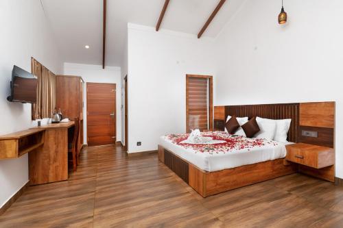 a bedroom with a bed and a television in it at Tealawn Pool Villa, Munnar in Munnar