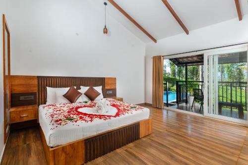a bedroom with a bed with red flowers on it at Tealawn Pool Villa, Munnar in Munnar