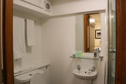 a white bathroom with a sink and a toilet at Lower Turks Head in Manchester