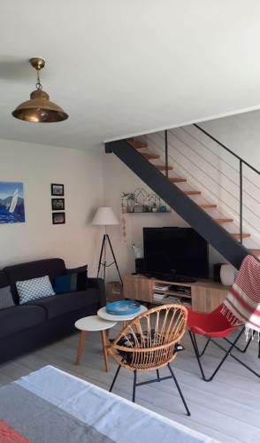 un salon avec un canapé et un escalier dans l'établissement Très belle Maison avec patio proche de la MER !, à Les Sables-dʼOlonne