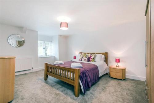 een slaapkamer met een bed, een bank en een raam bij Revelstoke Park House in Noss Mayo