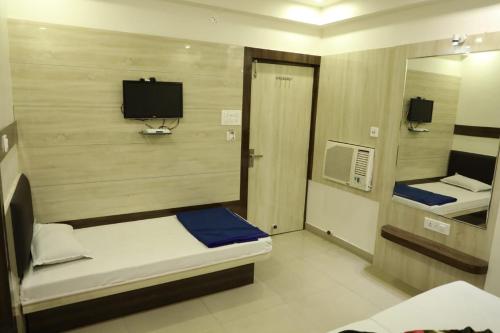 a small room with a bed and a mirror at Hotel Sahil 4 Min Distance from Dargah in Ajmer