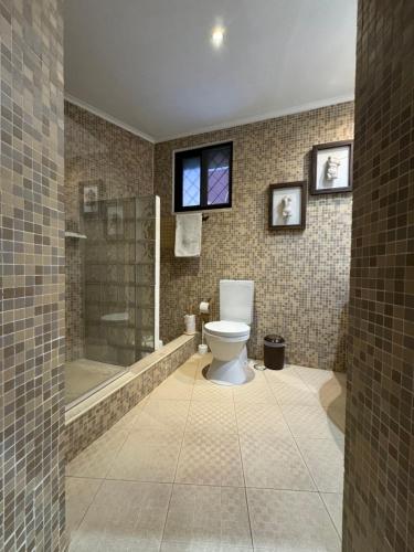 a bathroom with a toilet and a shower and a window at Quinta da Vitoria in Sacavém