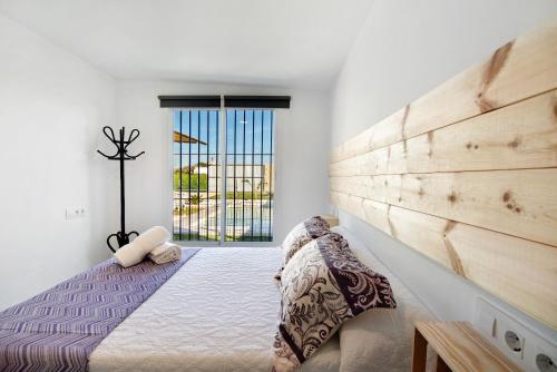 a bedroom with a bed with a wooden headboard at Casa la Viña in Chiclana de la Frontera