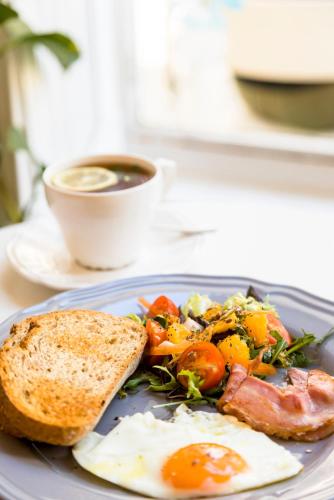 a plate of food with an egg and toast and a cup of coffee at B&B Pousada Swiss Residence in Aquiraz