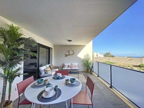 un salon avec une table et des chaises sur un balcon dans l'établissement Appartement de type T3 - Résidence avec piscine, à Calvi