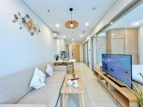 a living room with a couch and a large screen tv at The Song Luxury Vung Tau Apartment - QUỲNH's Homestay in Vung Tau
