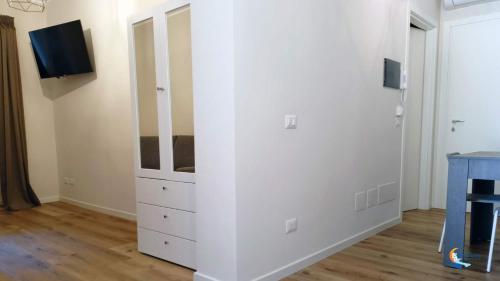 a room with a white wall with a dresser at Baia di Luna in Santa Marinella
