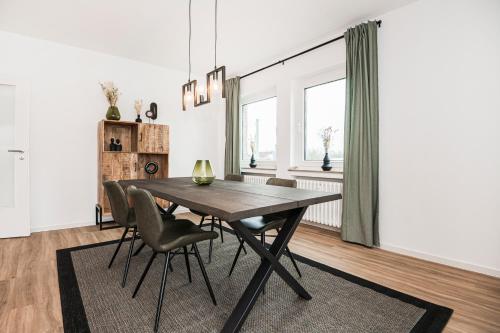 een eetkamer met een houten tafel en stoelen bij Artful Stay for 4 in Krefeld