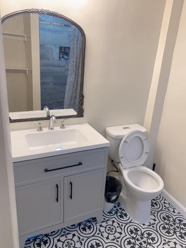 a bathroom with a sink and a toilet with a mirror at Brand new bedroom next Camden yard , convention center in Baltimore