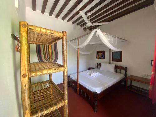 a bedroom with a bunk bed and a ladder at Oasis Bungalows in Jambiani