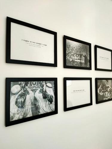 a group of framed pictures on a white wall at Minimà Peschici in Peschici