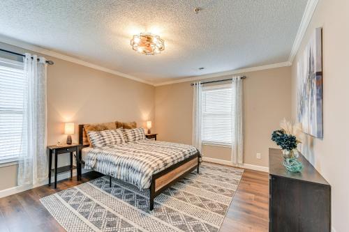 a bedroom with a bed and two windows at Winston-Salem Condo with Balcony Steps to Golf! in Winston-Salem
