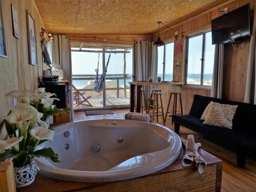 a large tub in a living room with a view of the ocean at NewViejoBlanco in Punta Del Diablo