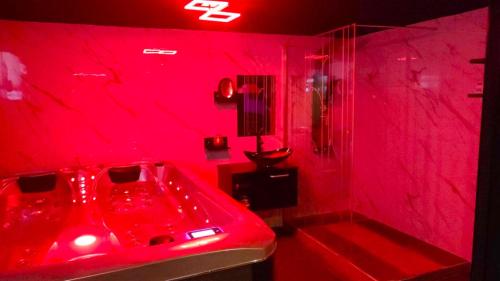 baño rojo con bañera roja y ducha en La Secrète en Barlin