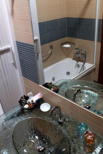 a bathroom with a sink and a tub and a mirror at Las Fontaninas in Noceda del Bierzo