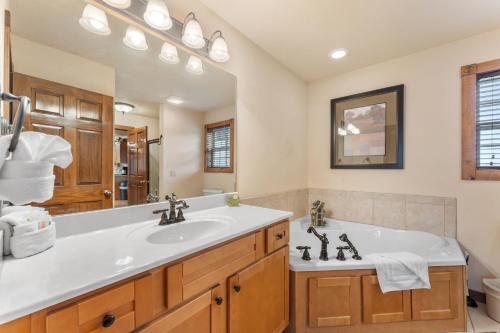 a bathroom with a sink and a large mirror at Lazy JC Lodge lodge in Branson West