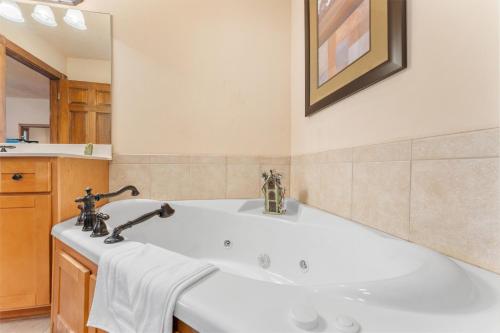 a bathroom with a tub and a sink at Lazy JC Lodge lodge in Branson West