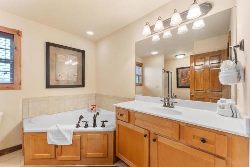 a bathroom with a large tub and a sink at Lazy JC Lodge lodge in Branson West
