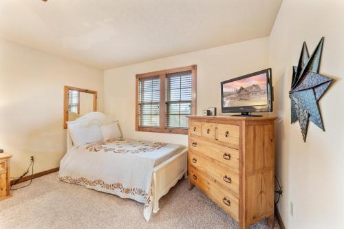 a bedroom with a bed and a wooden dresser at Lazy JC Lodge lodge in Branson West