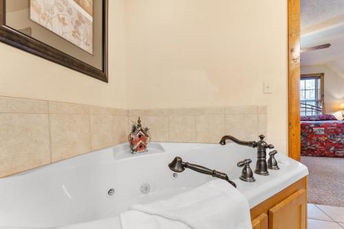 a bathroom with a white tub and a sink at Lazy JC Lodge lodge in Branson West