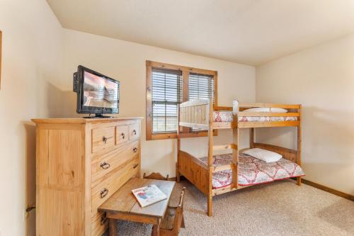 a bedroom with a bunk bed and a television at Lazy JC Lodge lodge in Branson West