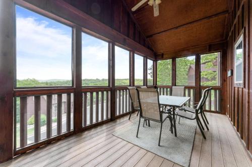 a dining room with a table and chairs on a balcony at Lazy JC Lodge lodge in Branson West
