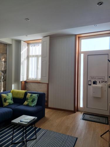 a living room with a blue couch and a window at Honey House in Matosinhos