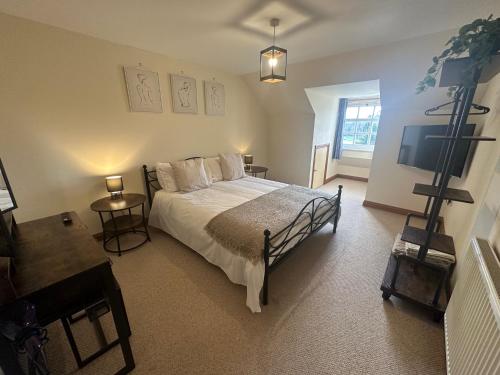a bedroom with a bed and a flat screen tv at Riverside in Brecon