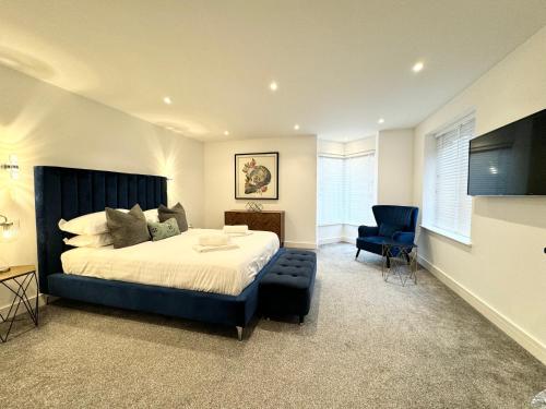 a bedroom with a large bed and a blue chair at Eagles Cottage, Ulverston - Lake District in Ulverston