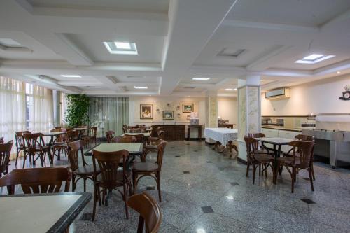 restauracja ze stołami i krzesłami w pokoju w obiekcie Hotel Apollo w mieście Uberlândia
