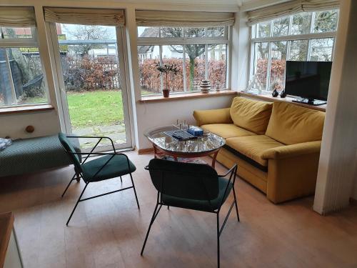 a living room with a couch and a table and chairs at Slotsgaardens hus in Jels
