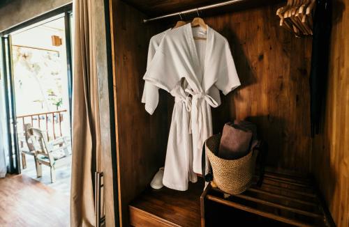 a white robe hanging on a wall in a room at Sand in My Shoes Beach Loft in Thong Nai Pan Noi