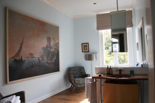 La salle de bains est pourvue d'un lavabo et d'une peinture murale. dans l'établissement La Maison Jules, à Tours