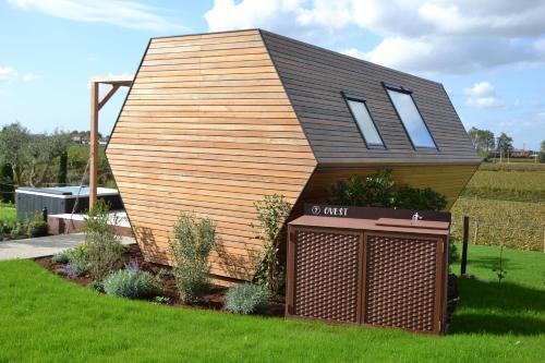 a small house with a roof on top of a yard at Glamping Alvearium Alturis in Gagliano