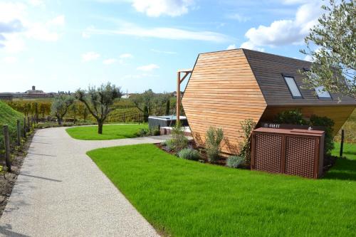 a small house with a green lawn and a sidewalk at Glamping Alvearium Alturis in Gagliano