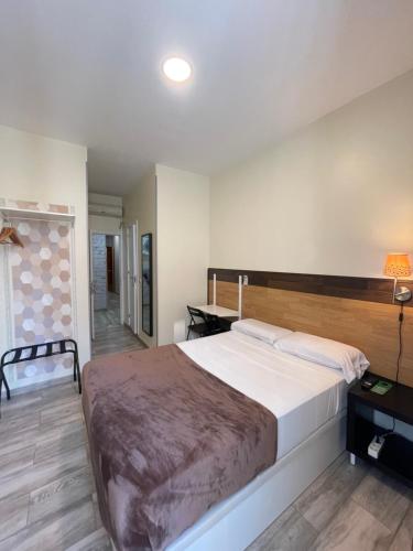 1 dormitorio con 1 cama grande y cabecero de madera en Hostal Oliver, en Madrid
