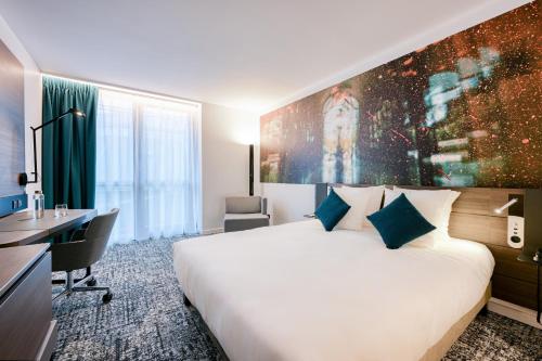 a hotel room with a large bed and a desk at Novotel Paris Centre Bercy in Paris