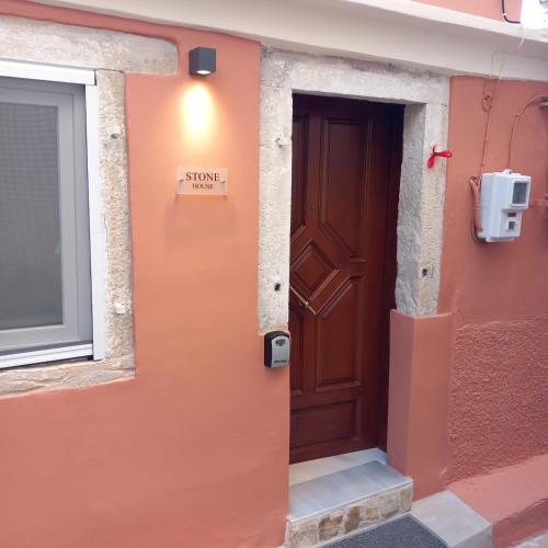a door to a building with a sign on it at stone house in Mantoúkion