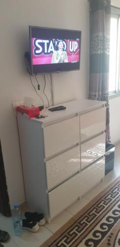 ダカールにあるChez mimaの部屋のドレッサーの上にテレビが付いています。